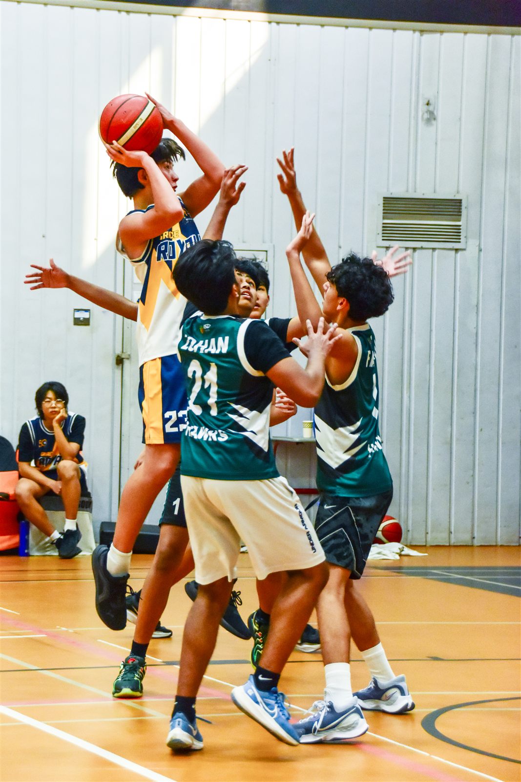 Elijah, wearing number 23, rising for a shot over three defenders
